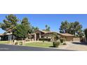 Attractive front view of the property showcasing lush, mature landscaping at 1348 E Los Arboles Dr, Tempe, AZ 85284