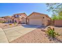Spacious home featuring a wide driveway, two-car garage, and desert landscaping at 1385 E Martha Dr, Casa Grande, AZ 85122