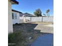 Spacious backyard featuring block fence, gravel landscaping, and concrete patio area under a clear blue sky at 18828 N 17Th Dr, Phoenix, AZ 85027