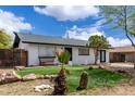 Charming home featuring black and white paint, modern design, desert landscaping, and green grass at 1985 S Plaza Dr, Apache Junction, AZ 85120