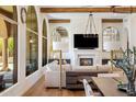 Elegant living room featuring a fireplace, wood beams, large windows, and hardwood floors at 21397 N 78Th St, Scottsdale, AZ 85255