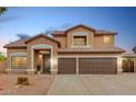 Inviting two-story home with a three-car garage, desert landscaping, and stone accents at 2143 N Chestnut Cir, Mesa, AZ 85213