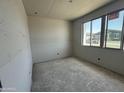 Bedroom featuring large window, smooth grey concrete flooring and grey unfinished walls at 2356 E Spur Dr, San Tan Valley, AZ 85140