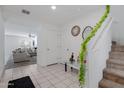 Bright foyer with tile flooring, white walls, and a staircase at 25457 W Clanton Ave, Buckeye, AZ 85326