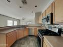 Open concept kitchen area features stainless steel appliances, tile flooring, and ample counter space at 2600 E La Costa Dr, Chandler, AZ 85249