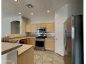 Well-equipped kitchen features stainless steel appliances, light wood cabinets, and tile backsplash at 2600 E La Costa Dr, Chandler, AZ 85249