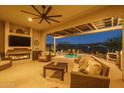 Spacious covered patio with fireplace, ceiling fan, and furniture overlooking pool at 26673 W Ponderosa Ln, Buckeye, AZ 85396