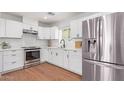 Modern kitchen features stainless steel appliances, white cabinets, and wood-look flooring at 3733 W Flynn Ln, Phoenix, AZ 85019