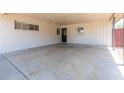 Spacious covered carport featuring a concrete floor, a white brick wall, and backyard access at 4713 E Cambridge Ave, Phoenix, AZ 85008