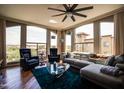 Bright living room featuring a sectional sofa, blue rug, hardwood floor, and chairs by the windows at 5350 E Deer Valley Dr # 4239, Phoenix, AZ 85054