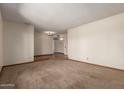 Spacious living room with neutral carpeting, seamlessly connecting different areas of the home at 5421 W Seldon Ln, Glendale, AZ 85302