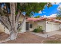 Inviting single-story home with a two-car garage, mature tree, and a well-manicured front yard at 5428 W Wethersfield Dr, Glendale, AZ 85304