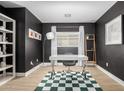Home office with stylish, dark walls, natural light, modern desk and a decorative checkered rug at 672 S Porter St, Gilbert, AZ 85296