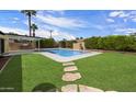 Lush backyard features pool, grass, and outdoor BBQ, perfect for entertaining at 7502 E Princeton Ave, Scottsdale, AZ 85257