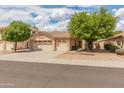 Charming single-story home with a well-maintained front yard, desert landscaping, and a three-car garage at 7916 W Mary Ann Dr, Peoria, AZ 85382