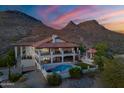 Stunning sunset aerial view of an estate with a pool nestled against picturesque mountains at 1234 E Claire Dr, Phoenix, AZ 85022