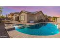 Inviting backyard with a sparkling pool and spa, complemented by a spacious patio area at 13155 W Monterey Way, Litchfield Park, AZ 85340