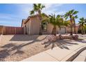 Single-Gathering home featuring desert landscaping, a two-car garage and mature palm trees at 13155 W Monterey Way, Litchfield Park, AZ 85340