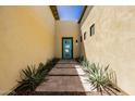 Charming home entrance with a bright turquoise door and lush landscaping for added curb appeal at 1341 E Paseo Way, Phoenix, AZ 85042