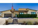 Front exterior of home with a flag pole, lush green bushes, and a blue front door at 1341 E Paseo Way, Phoenix, AZ 85042