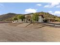 Spacious property with a white two-story home featuring a red tile roof, mature trees, and desert landscaping at 1500 N Crismon Rd, Mesa, AZ 85207