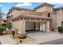 Charming two-story home featuring an open two-car garage, desert landscaping, and a decorative stone facade at 19700 N 76Th St # 2169, Scottsdale, AZ 85255