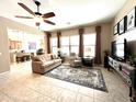 Bright living room features tile floors, sofa, recliner, media center, and a ceiling fan for added comfort at 20525 W Hamilton St, Buckeye, AZ 85396