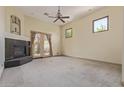 Spacious living room with a fireplace, ceiling fan, and French doors to the backyard at 2060 E Prescott Pl, Chandler, AZ 85249