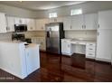 This bright kitchen features white cabinets, stainless steel appliances, and dark wood flooring at 2074 N 109Th N Ave, Avondale, AZ 85392