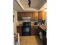Traditional kitchen with wood cabinets, black appliances, and tile floor at 2141 W Elm St, Phoenix, AZ 85015