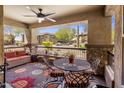 Relaxing outdoor patio with comfortable seating, ceiling fan, and views of the surrounding community landscape at 2425 W Bronco Butte Trl # 1056, Phoenix, AZ 85085