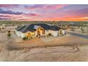 Eye-level aerial view of a modern home featuring desert landscaping and exterior lighting at dusk at 35280 N Bell Rd, Queen Creek, AZ 85144