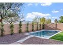 Inviting pool is surrounded by desert landscaping and trimmed trees that create a peaceful retreat at 4360 N 186Th Ln, Goodyear, AZ 85395