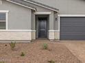 Close up on a single-story home's front door and garage, featuring manicured gravel landscaping at 4777 W Hunter Trl, San Tan Valley, AZ 85144