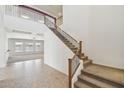 Grand foyer featuring a staircase with wooden banister and wrought iron, and tile flooring at 5557 W Mine Trl, Phoenix, AZ 85083