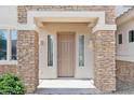 Elegant front entryway featuring a stone facade, stylish sidelights, and a neutral-colored door at 5557 W Mine Trl, Phoenix, AZ 85083
