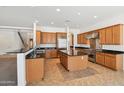Spacious kitchen with stainless steel appliances, wood cabinets, black granite countertops, and tile floors at 5557 W Mine Trl, Phoenix, AZ 85083