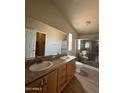 Bathroom featuring double sinks, wood cabinets, and a glass-enclosed shower at 6839 W Taylor St # 209, Phoenix, AZ 85043