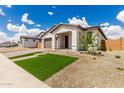 Charming single-story home featuring lush synthetic grass, desert landscaping, and a brick driveway at 7342 W Hedge Hog Pl, Peoria, AZ 85383