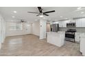 Open-concept living space with updated floors, ceiling fans, and seamless access to the modern kitchen at 8132 W Earll Dr, Phoenix, AZ 85033