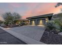 Beautiful home exterior showcasing the three-car garage with desert landscaping at 11935 E Casitas Del Rio Dr, Scottsdale, AZ 85255