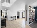 Spacious living area with tiled floors, large windows, and a built-in bookcase at 13637 W Port Royale Ln, Surprise, AZ 85379