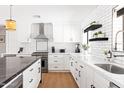 Modern kitchen with white cabinets, black hardware, and a stainless steel range hood at 1609 W State Ave, Phoenix, AZ 85021