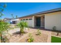 Charming home featuring a well-manicured front yard, desert landscaping, and an inviting front entrance with a decorative door at 17411 N 36Th St, Phoenix, AZ 85032