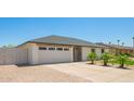 A bright exterior with a two-car garage, white brick, gray roof, and low maintenance desert landscaping at 17411 N 36Th St, Phoenix, AZ 85032