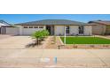 Attractive single-story house with a meticulously landscaped front yard featuring desert plants and a green artificial lawn at 17411 N 36Th St, Phoenix, AZ 85032
