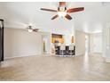 Expansive living room with tile floors, ceiling fans, and an open floor plan connecting to the kitchen at 18013 N Sterling Dr, Surprise, AZ 85374
