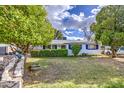 Single-story home with a well-maintained front yard, mature trees, sidewalk and hedge at 1849 E Jarvis Ave, Mesa, AZ 85204