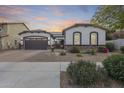 Charming single-story home with a well-manicured yard, desert landscaping, and a two-car garage at sunset at 20017 S 192Nd Pl, Queen Creek, AZ 85142