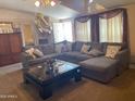 Inviting living room featuring a large sectional sofa, a coffee table, and neutral decor, creating a warm and cozy atmosphere at 2028 E Libby St, Phoenix, AZ 85022